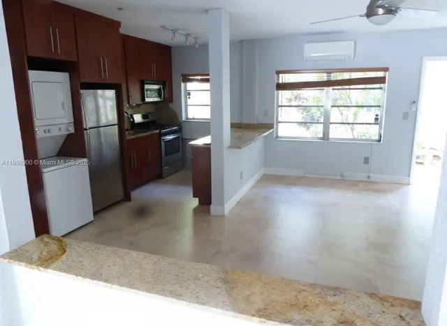a kitchen with granite countertop a refrigerator and a sink