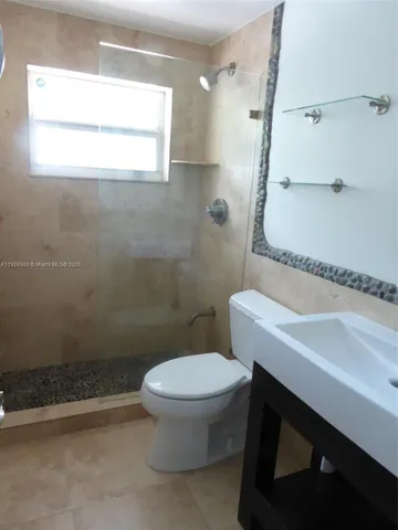 a white toilet sitting next to a bathroom sink