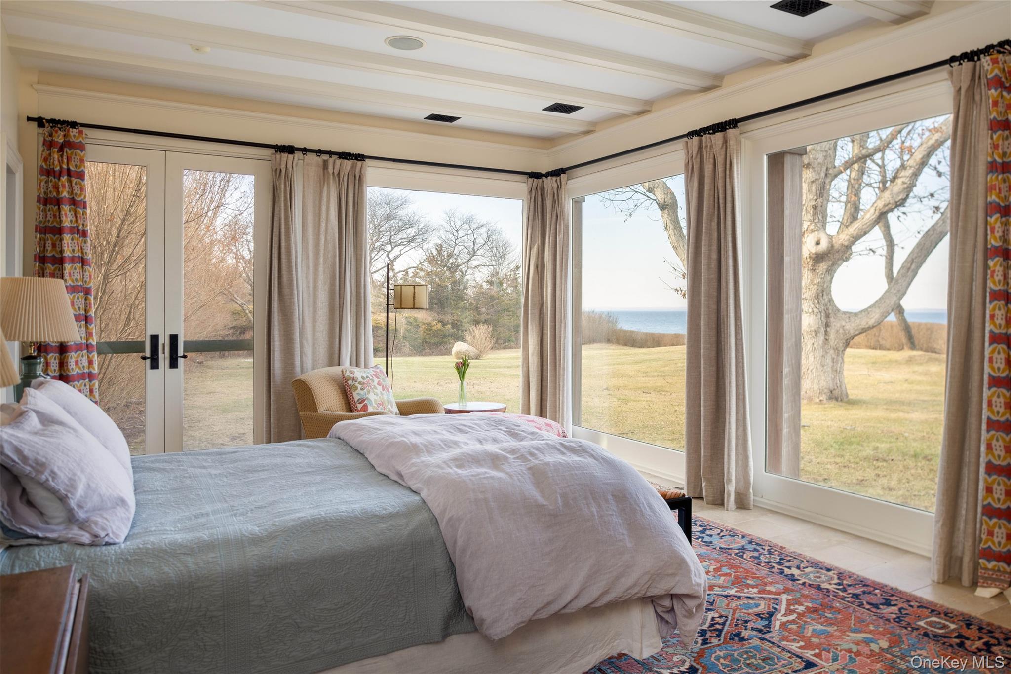 2840 Stars Road East Marion, NY 11939 - Photo 18 of 43 a bedroom with a large bed and a large window with outer view