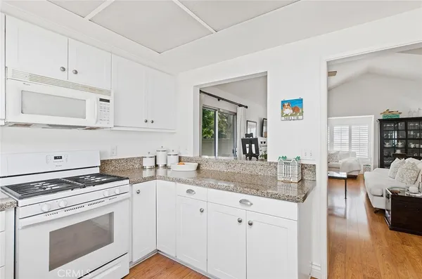 a kitchen with granite countertop a sink stove and cabinets