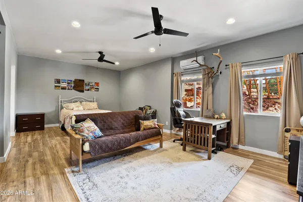 a living room with furniture kitchen view and a wooden floor