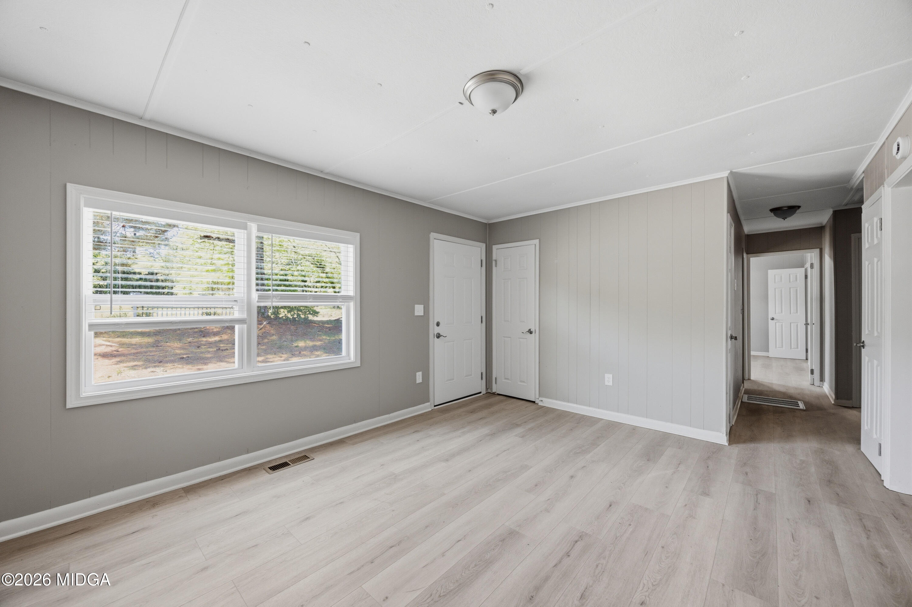 427 Gun Club Road Fort Valley, GA 31030 - Photo 3 of 26 a view of an empty room with wooden floor and a window