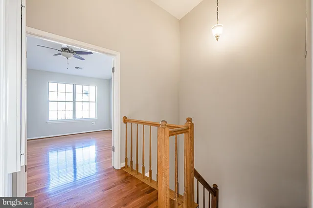a view of a hallway with wooden floor and staircase