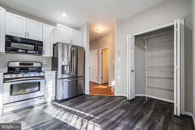 a kitchen with wooden floors and stainless steel appliances