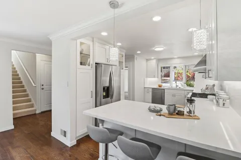 a kitchen with a dining table chairs refrigerator and cabinets