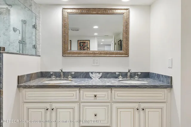 a bathroom with a granite countertop double sink and a mirror