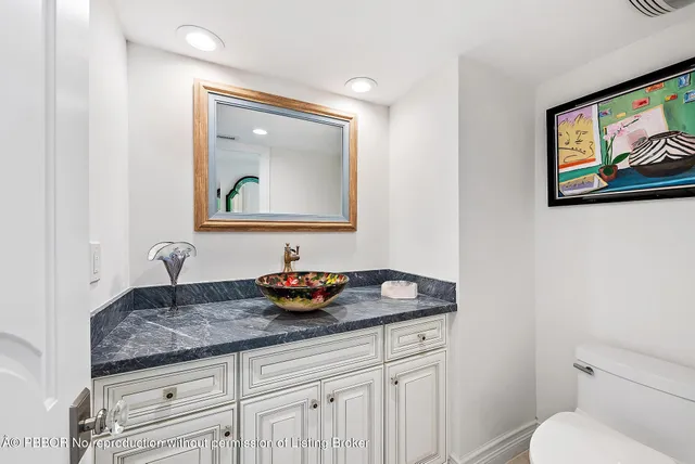 a bathroom with a toilet a sink and mirror