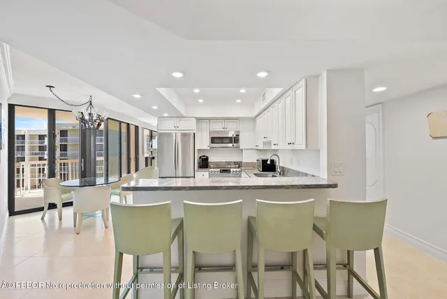 a kitchen with stainless steel appliances granite countertop a table and chairs in it