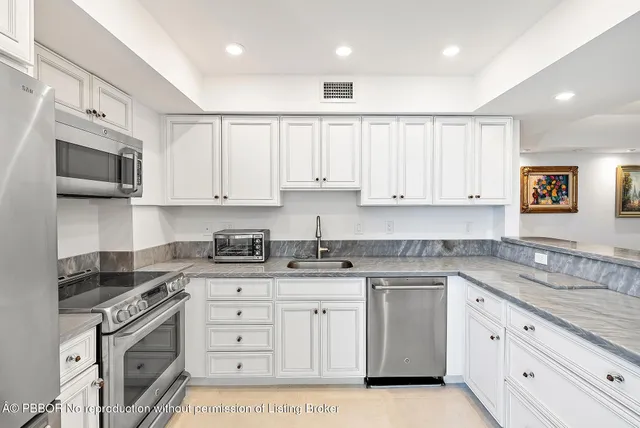 a kitchen with granite countertop white cabinets white stainless steel appliances with a sink and dishwasher