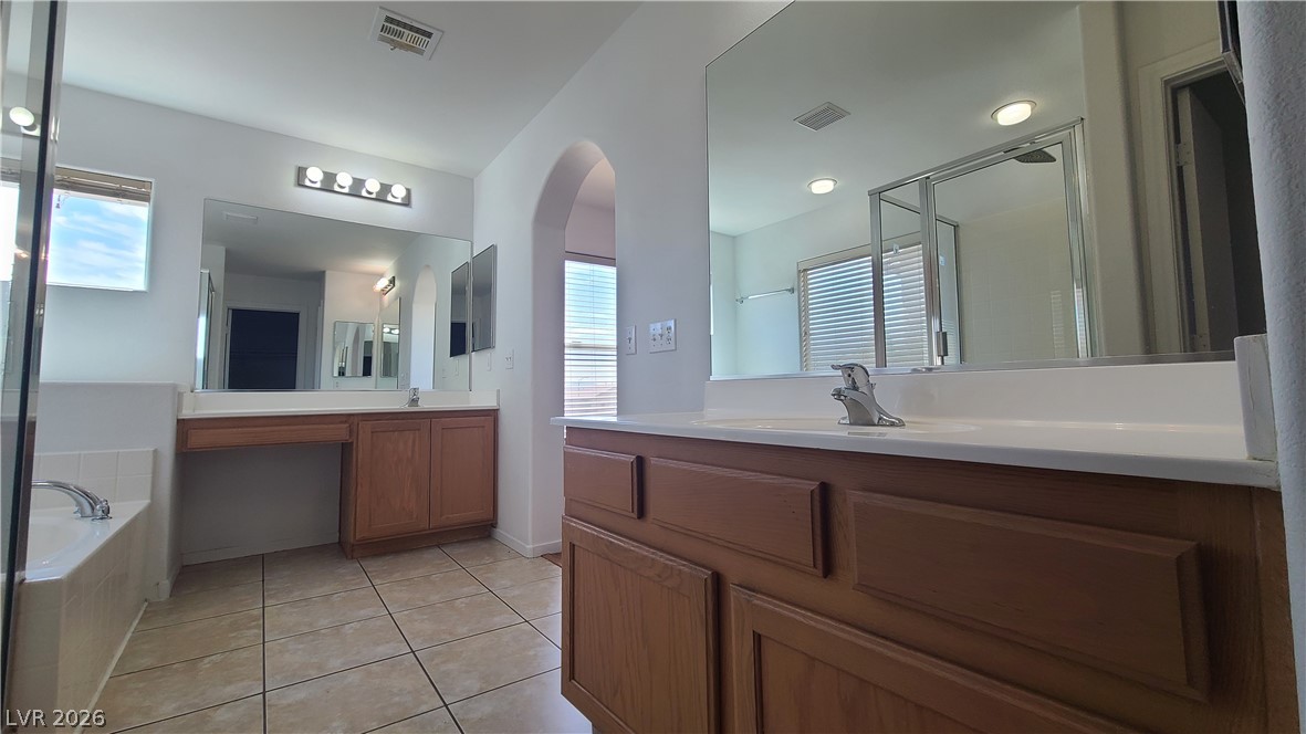 8944 Rutherford Grove Street Las Vegas, NV 89148 - Photo 22 of 35 Dual vanities with expansive counter space and a deep soaking tub create a personal spa retreat.