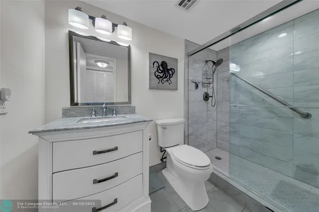 a bathroom with a granite countertop sink toilet a mirror and shower