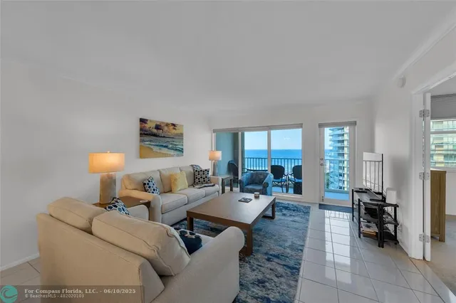 a living room with furniture a large window and a rug