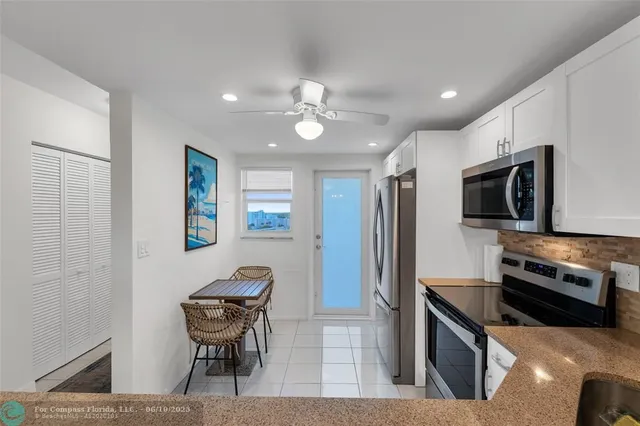 a kitchen with stainless steel appliances kitchen island granite countertop a refrigerator and a stove top oven