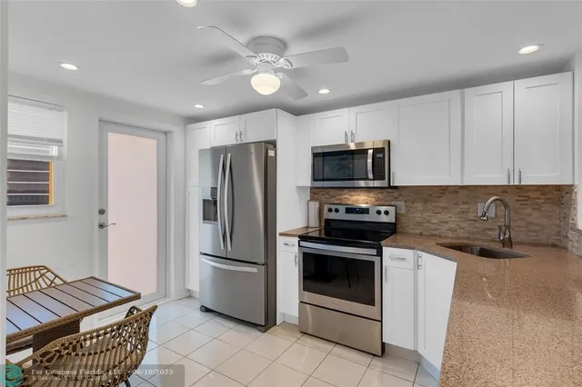 a kitchen with stainless steel appliances granite countertop a refrigerator a stove a sink and a microwave