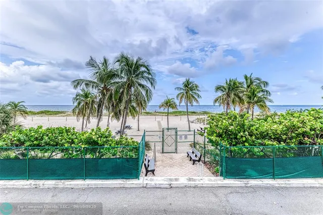 a palm tree sitting in front of a house with a garden