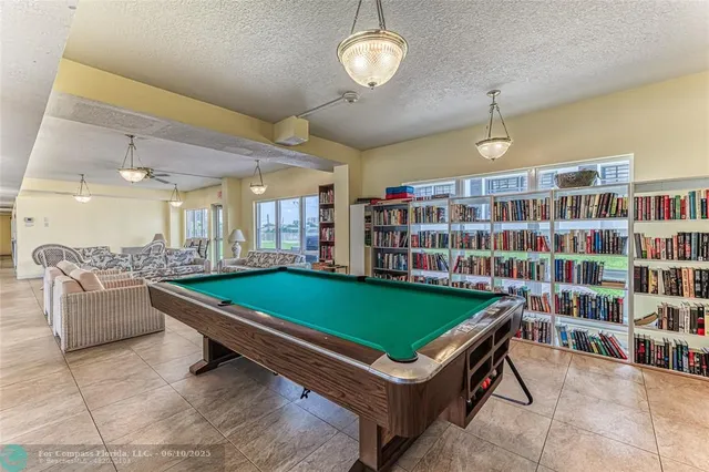a room with pool table and windows
