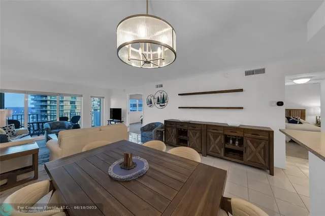 a kitchen with stainless steel appliances granite countertop a stove a sink dishwasher and white cabinets with wooden floor