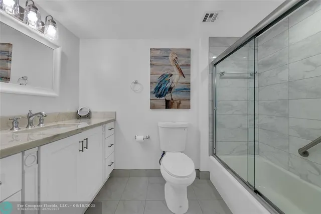 a bathroom with a granite countertop sink a toilet and shower