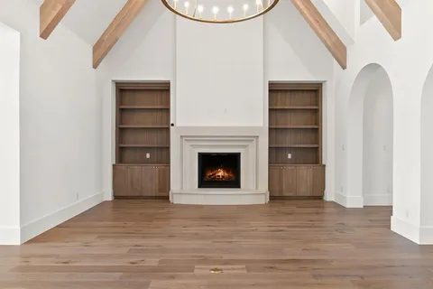 a view of an empty room with a fireplace and a window