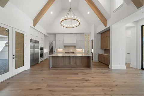 a large kitchen with stainless steel appliances a large counter top and a refrigerator