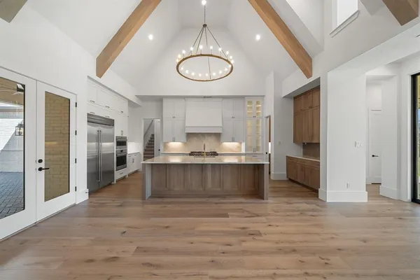 a large kitchen with stainless steel appliances a large counter top and a refrigerator