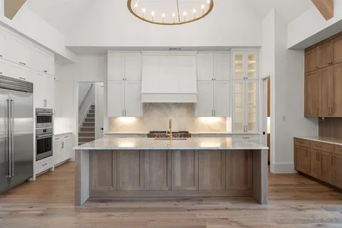 a kitchen with stainless steel appliances granite countertop a sink a refrigerator and a stove