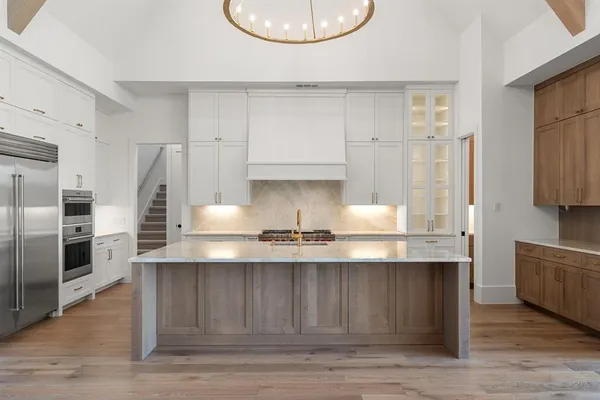 a kitchen with stainless steel appliances granite countertop a sink a refrigerator and a stove