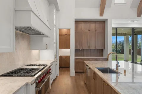 a kitchen with granite countertop a sink stove and cabinets