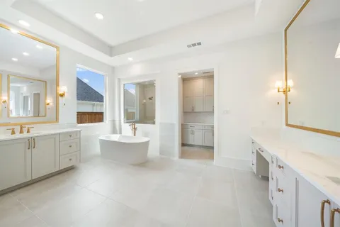 a bathroom with a double vanity sink toilet mirror and bathtub