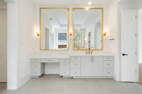 a spacious bathroom with a double vanity sink a mirror and a bathtub