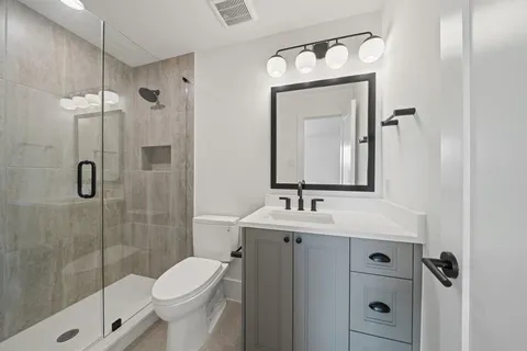 a bathroom with a toilet sink shower and mirror