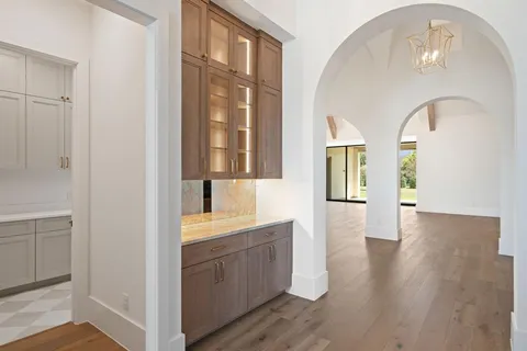 a hallway with wooden floors and cabinet