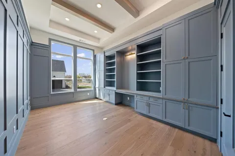 a view of an empty room with a window and cabinet