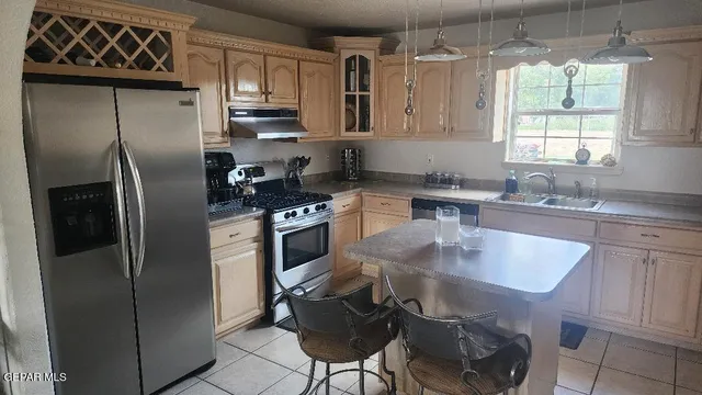 a kitchen with stainless steel appliances granite countertop a sink a stove a refrigerator and cabinets