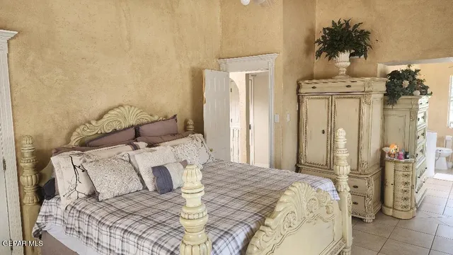 a bedroom with a bed a mirror and dresser