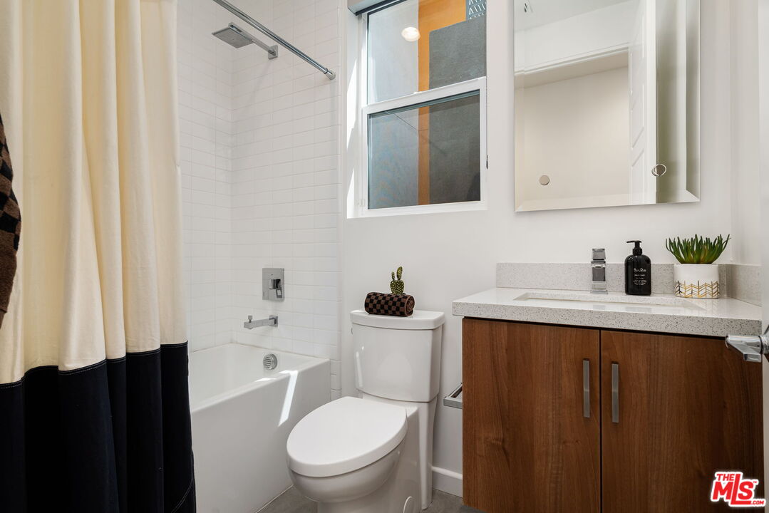 504 Paragon Loop Palm Springs, CA 92262 - Photo 10 of 19 a bathroom with a sink a toilet and shower curtain
