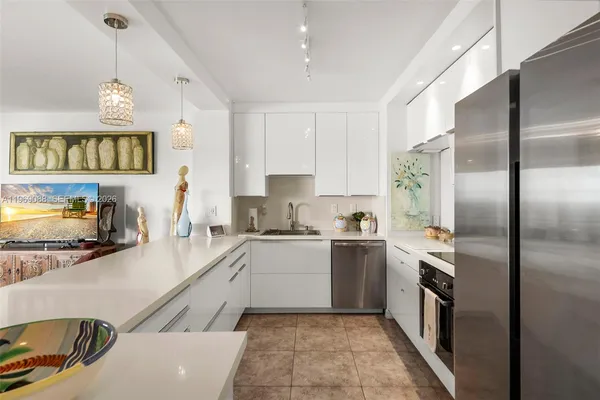 a kitchen with stainless steel appliances granite countertop a sink a stove and a refrigerator