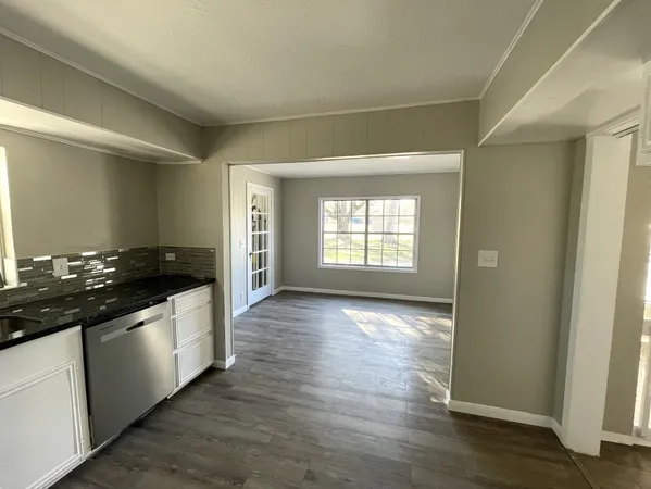 a view of a kitchen with a sink wooden floor and a window