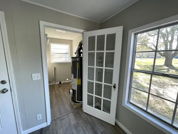 a view of empty room with wooden floor and windows