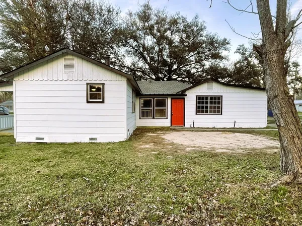 a view of a backyard of house with a large tree