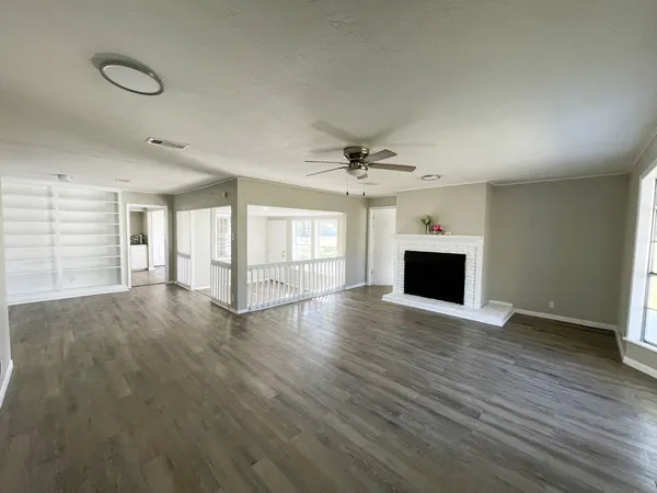 a view of empty room with wooden floor and fireplace