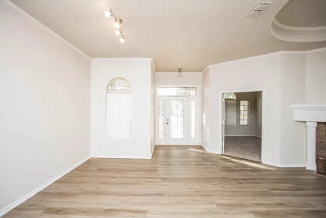 an empty room with a window and a fan