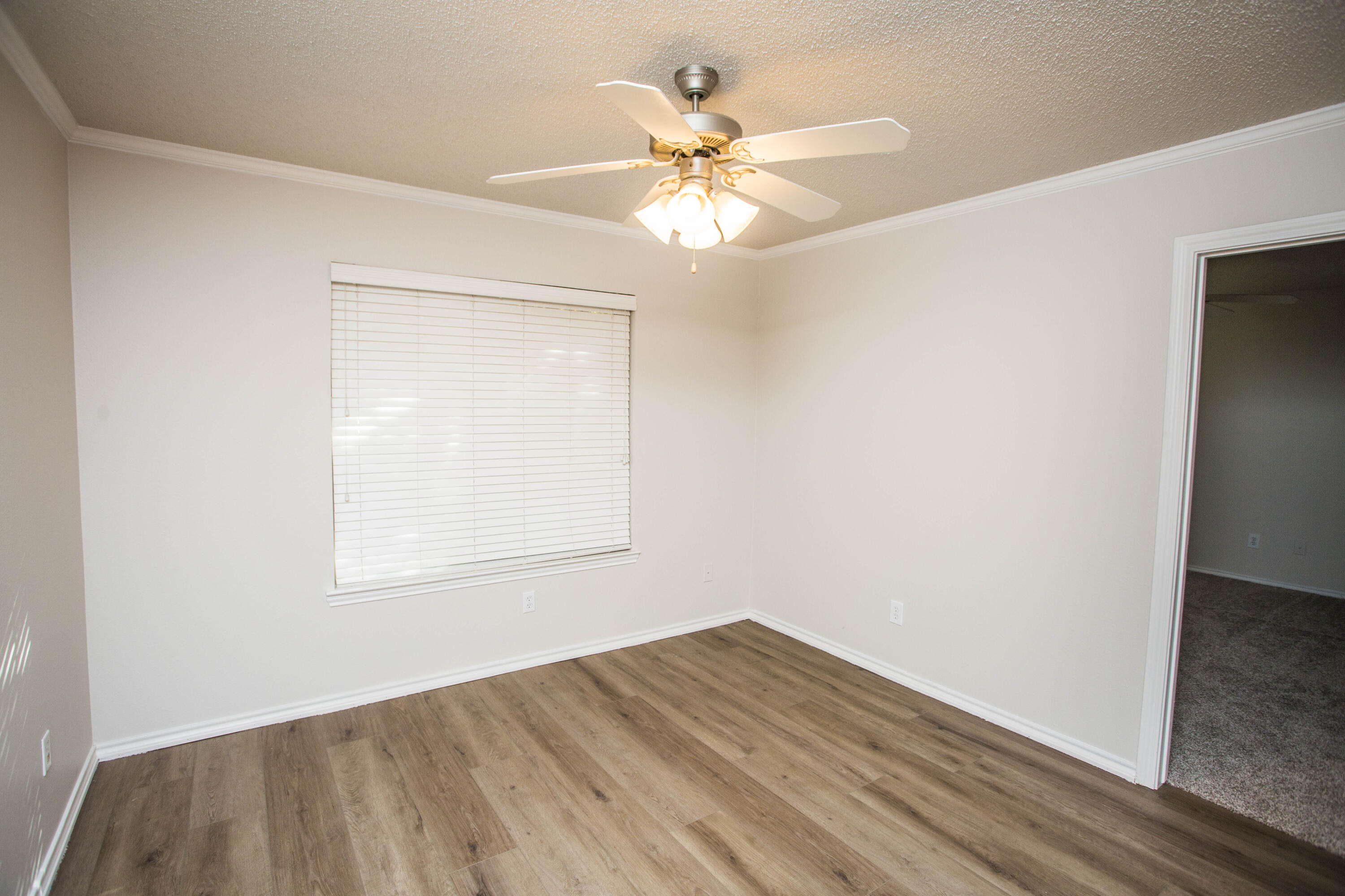 616 North 8th Street Wolfforth, TX 79382 - Photo 29 of 50 an empty room with wooden floor fan and windows