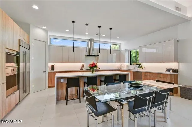a kitchen with stainless steel appliances kitchen island granite countertop a sink and white cabinets