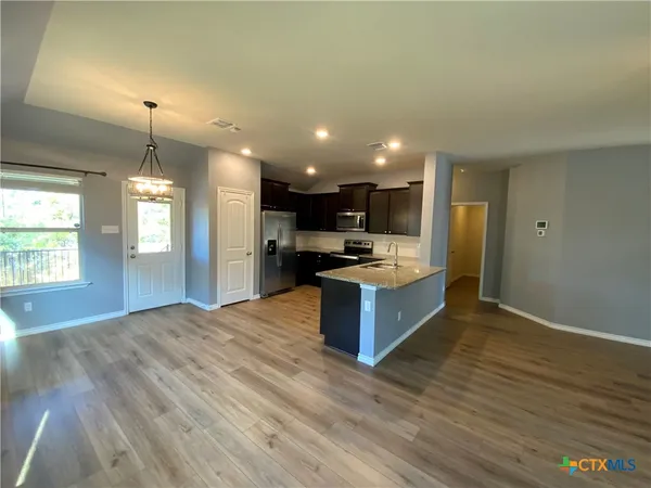 a large kitchen with kitchen island a sink stainless steel appliances and cabinets