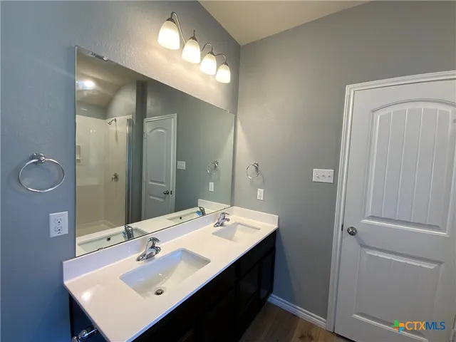 a bathroom with a sink double vanity granite and a mirror