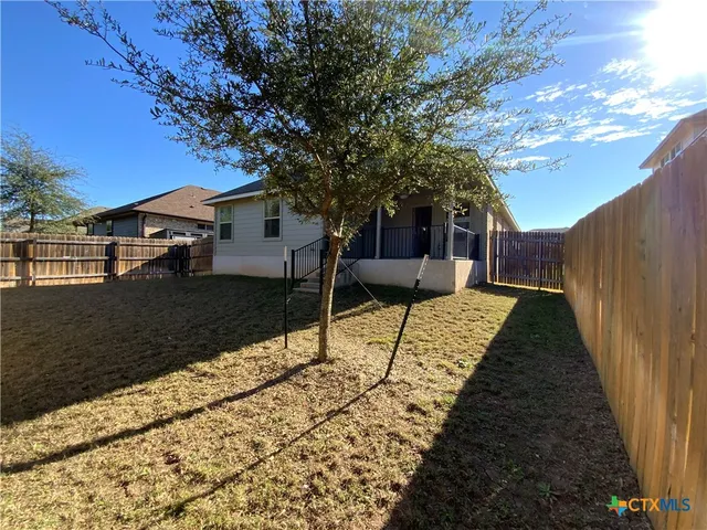 a view of house with backyard and trees