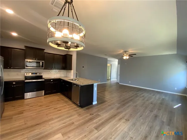 a kitchen with granite countertop a stove and a wooden floor
