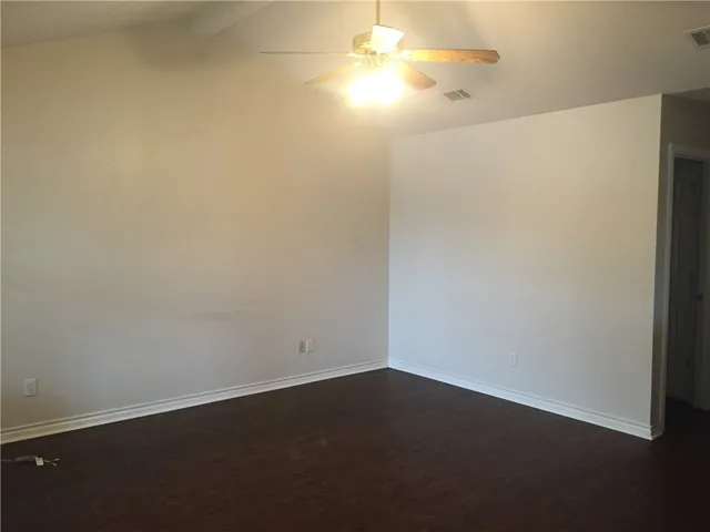 an empty room with a fan and a window