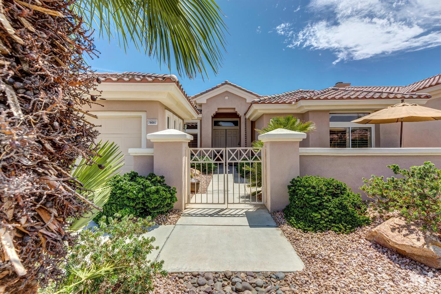 78087 Hunter Point Road Palm Desert, CA 92211 - Photo 36 of 37 a view of a white house with a flower garden and potted plants